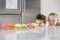 Siblings Peeking Over Counter At Row Of Cupcakes