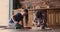 Siblings play at home with toy railroad and wooden blocks