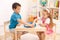 Siblings playing chess in the kid\'s room