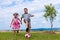 Siblings playing soccer in the garden