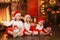 Siblings sisters in santa hats near fireplace on Christmas ligh