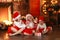 Siblings sisters in santa hats near fireplace on Christmas ligh