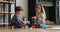 Siblings sit on floor in living room play plastic cubes