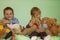 Siblings sitting in the middle of all her stuffed animals