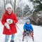 Siblings sledding in winter through