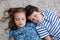 Siblings sleeping on rug in living room