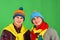 Siblings stand close and smile. Guys in knitted scarves