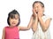 Siblings teasing, asian little girl pulling her sister\'s ear