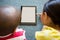 Siblings using digital tablet on carpet