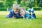 Siblings using a tablet, yingon grass in the park in suny day