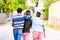 Siblings walking down the village road