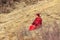 SICHUAN, CHINA - MAY 3 2016: Monk sitting praying on grasses in the mountain at Larung GarLarung Buddhist Academy. a famous Lama