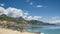 Sicilian beach in Giardini Naxos and ancient Taormina town on a hill in Sicily