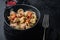 Sicilian tuna pasta shells with tomatoe and capers, on black background