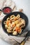 Sicilian tuna pasta shells with tomatoe and capers in bowl, on white background