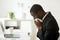 Sick african american businessman sneezing in tissue working in