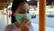 Sick asian child girl wearing protection mask against air pollution at bus stop in the city Bangkok,inhale fine dust,pm 2.5,female