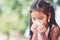 Sick asian child girl wiping and cleaning nose with tissue