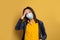 Sick black woman student in face mask on yellow background. Epidemic and virus protection concept