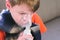 Sick boy inhaling through inhaler mask, face close-up side view. Use nebulizer and inhaler for the treatment.