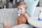 Sick boy in nebulizer mask making inhalation, respiratory procedure by pneumonia or cough for child, inhaler, compressor