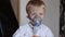 Sick child breathes through nebulizer, close-up.