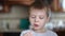 A sick child licks his fingers in sour cream