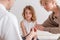 Sick cute little boy with flu at pediatrician`s office with his loving mother