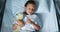 Sick girl resting with teddy bear on bed