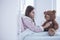 Sick girl with stethoscope examining teddy bear in the hospital