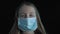 Sick girl wears medical face mask. Portrait of a sick girl in a medical mask on black background