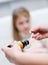 Sick little girl awaits her medication pouring in a spoon in the foreground