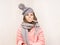 Sick little girl with sad face and thermometer in mouth wear in scarf and hat