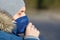 Sick man in blue jacket with a hood having a cold, coughing and wearing medical face mask