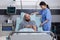 Sick man resting in bed while woman nurse arrange bed for sit comfortable