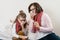 Sick mother and child sneezing in handkerchief, holding nasal spray, cold season