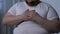 Sick obese male feeling chest pain, life-threatening heart problem, medicine