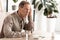 sick retired man with memory loss sitting near pills and bottles on table.