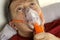 Sick senior adult man breathing through oxygen mask, rolling his eyes. Treatment of asthma, allergies, bronchitis, pneumonia in