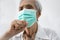 Sick senior woman wearing face mask,has seasonal influenza.,flu,common cold, illness and coughing a lot,elderly suffering from