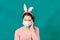 Sick woman with face mask wearing an easter bunny ears