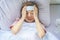 Sick woman lying on bed have fever and using a cooling pad on head