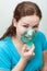 Sick woman with sore throat makes inhalation itself with a mask on her face. Nebulizer device