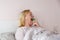 A sick woman sprays a medicinal spray into her throat with a sore throat