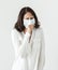 Sick woman wearing surgical mask coughing