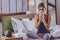 Sick young woman taking a glass of water from bedside table