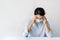 Sickness Asian girl wearing a medical face mask sitting at home over white background