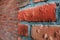 Side angle of a red brick wall corner. Close up view of cracked weathered brickwork material. Modern interior design, unique