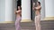 Side angle view portrait of two gorgeous women moving hands shaking hips performing in city. Confident graceful