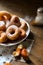 Side close up on a bunch of fresh homemade donuts with sugar and dark wooden background floor